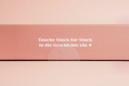 Junivia Vanlife Puzzle: Seitenansicht unseres Büchercafe Puzzle mit passendem Hörbuch mit Buchladenmotiv und Selbstfindungsgeschichte mit der Aufschrift "Tauche Stück für Stück in die Geschichte ein" 