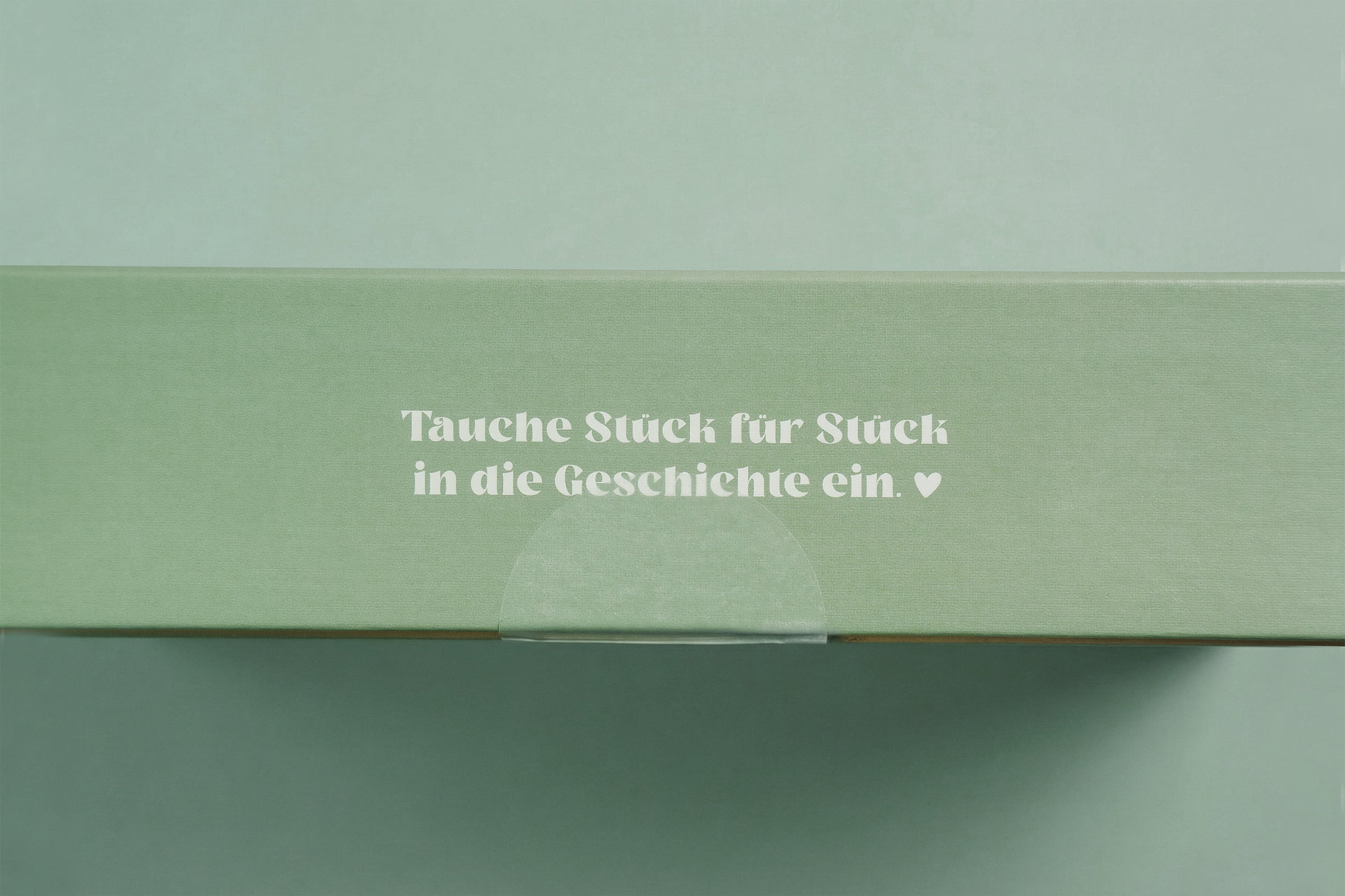 Junivia Vanlife Puzzle: Seitenansicht unseres Vanlife Puzzlekartons mit der Aufschrift "Tauche Stück für Stück in die Geschichte ein" 